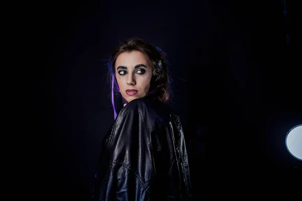 Girl in werewolf style on a black background with blue light.