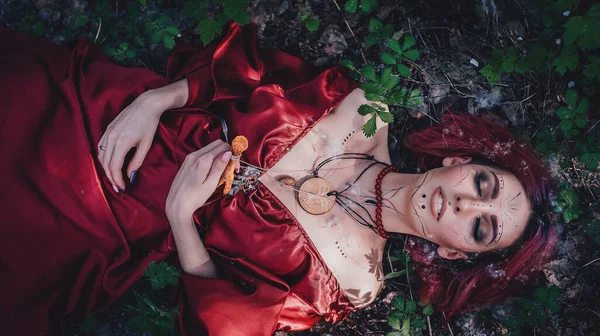 Kırmızı saçlı ve elma ağaçlarındaki Druid şeklinde bir kız.