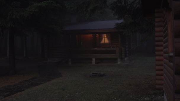 Janelas brilhantes na cabana de madeira na floresta de pinheiros nebulosos. Horror, conceito assustador — Vídeo de Stock