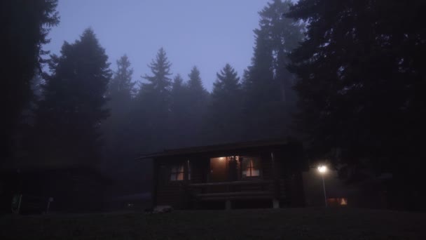Жуткая хижина в лесу в туманный вечер. Страшная, одинокая концепция — стоковое видео