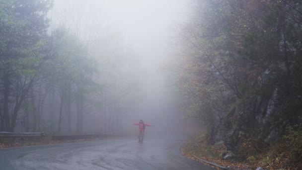 Uomo felice, turista che cammina su strada nebbiosa con braccia aperte e danza — Video Stock