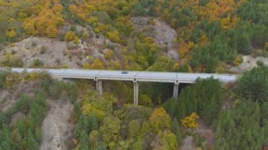 Dağlardaki güzel otoyol köprüsünün yan manzarası. Asfalt yolda giden arabalar