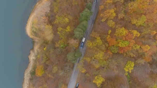 Drohne jagt Geländewagen oder Auto, die ein weißes Boot überholen und auf Asphaltstraße in der Nähe des klaren Sees fahren — Stockvideo