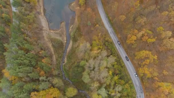 Drone następujące samochody jadące po niebezpiecznej drodze w górach w pobliżu jeziora — Wideo stockowe