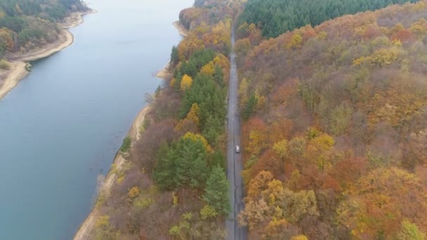 Drone suit excès de vitesse sur la route asphaltée près de la rive du lac 