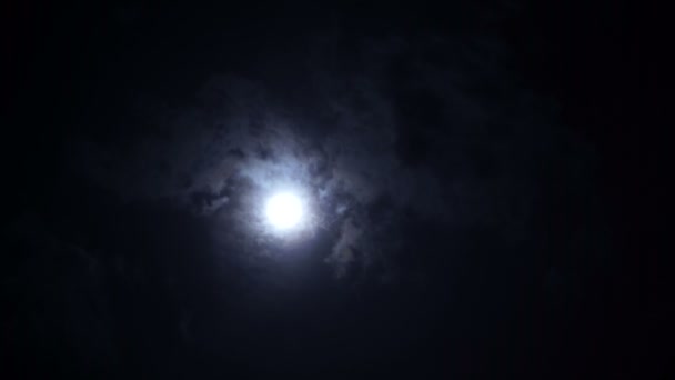 Clouds moving sideways across the full moon on a night sky. — Stock Video