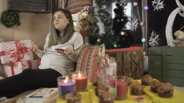 Junge schwangere Frau isst an Heiligabend Kuchen — Stockvideo
