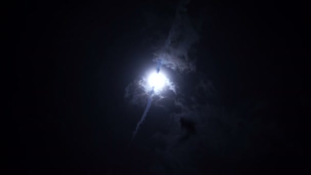 Luna llena parcialmente cubierta por nubes oscuras en el cielo nocturno — Vídeos de Stock
