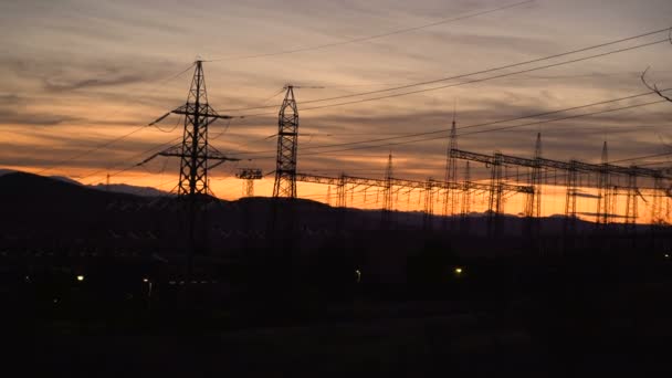 Poste eléctrico de alto voltaje y líneas eléctricas durante la puesta del sol — Vídeo de stock