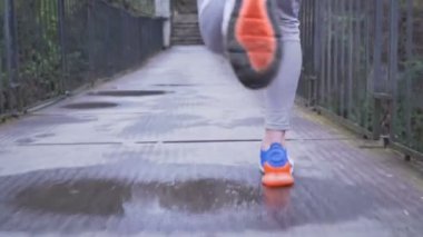 Asılı köprüde koşan renkli spor ayakkabılı erkek koşucu, yakın görüş.