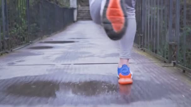 Männlicher Läufer in bunten Sportschuhen läuft auf Hängebrücke, Nahsicht — Stockvideo