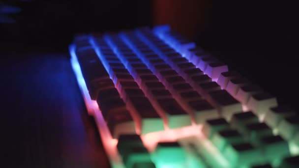 Vue latérale des mains masculines travaillant sur le clavier avec des touches lumineuses — Video