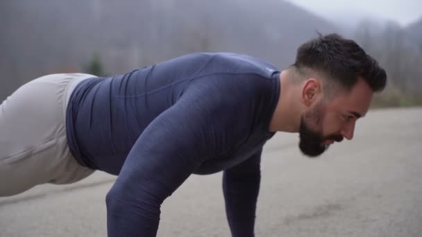 Fitness chico con cuerpo fuerte y grandes músculos haciendo flexiones al aire libre — Vídeo de stock