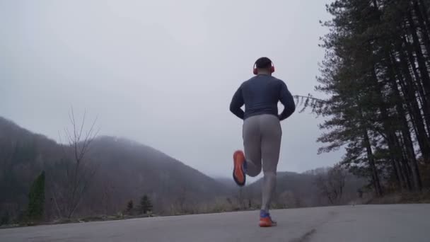 Following fitness man jogger training outdoors in foggy autumn day — Stock Video