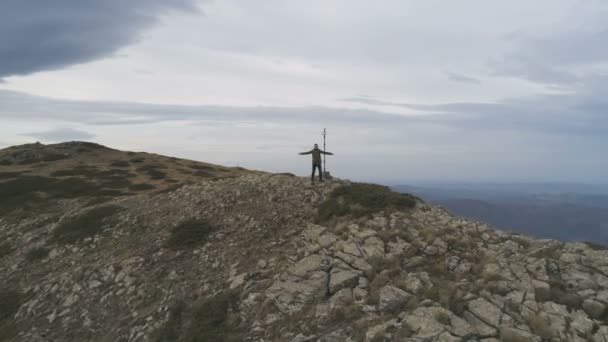 男徒步旅行者站在山顶上，胜利地举起双臂庆祝胜利 — 图库视频影像