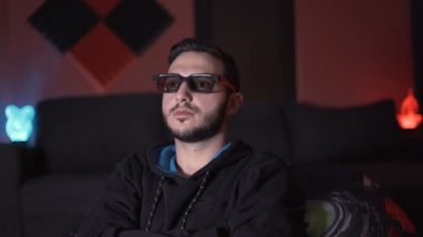Üç boyutlu gözlüklü bir adam evde film izliyor, harika şeyler yaşıyor.