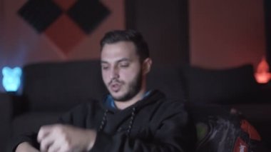 Erkek oyuncu VR gözlükleri ve kumandayla oyuna başlamadan önce ısınıyor ve parmaklarını esnetiyordu