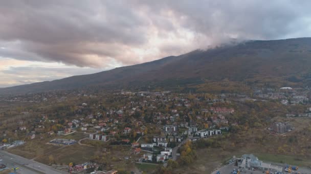 Вид с воздуха на живописные красочные облака над горой возле оживленной городской объездной дороги — стоковое видео