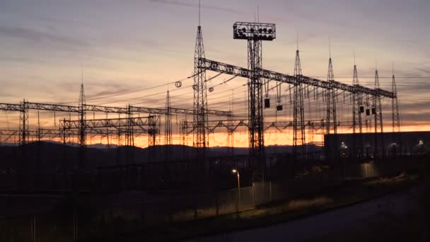 Silhouet Hoge spanning elektrische torens bij zonsondergang. Hoogspanningsleidingen. Elektriciteitsdistributiestation — Stockvideo