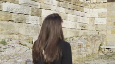 Ortaçağ kalesinde yürüyen kadın Çarevetler kalenin görünüşünden etkilendi.