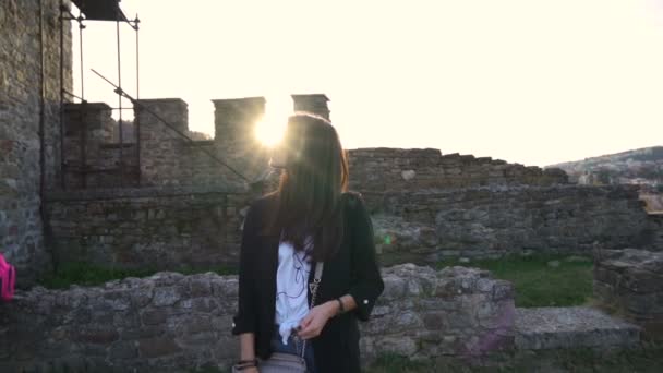 Meisje met lange bruine haar opening handtas, zorgeloos genieten van vakantie in Tsarevets kasteel — Stockvideo