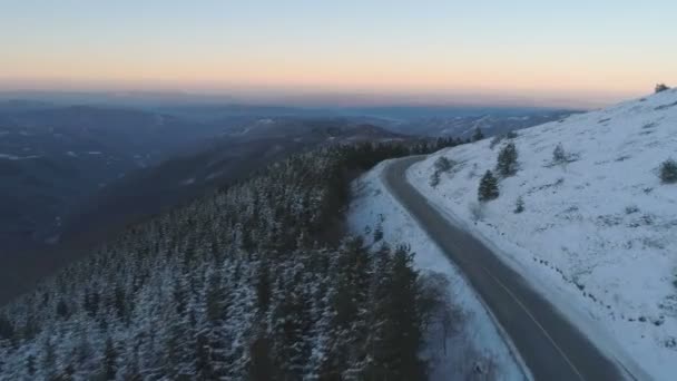 Dron následuje Bílý truck koryto zasněžené horské silnice v blízkosti zamrzlé věčně zelený les s panoramatickým výhledem — Stock video