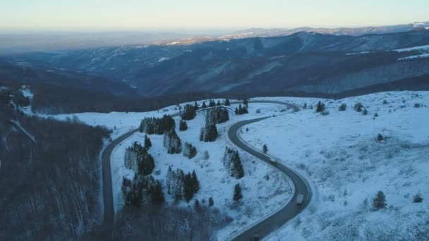 Vista aerea di tortuosa strada di montagna con camion e auto guida attraverso durante l'inverno — Video Stock