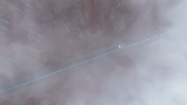 Drone follows white car driving slowly through dense fog at mountain road — 비디오