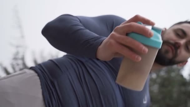 Low angle view of healthy strong man shaking protein shake during workout otdoors — 비디오