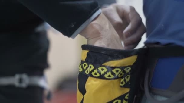 Альпинист покрывает руки порошковым мелом магнием, чтобы подняться внутрь — стоковое видео
