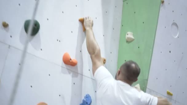 Сильный человек тренировки восхождение на крытую стену восхождения — стоковое видео