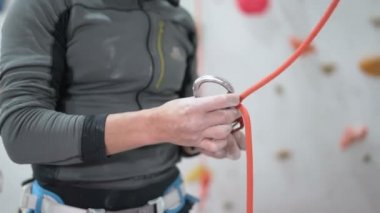 Male rescuer climbers with equipment preparing for practice indoors