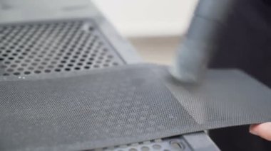 Male hands using vacuum cleaner to clean his computer
