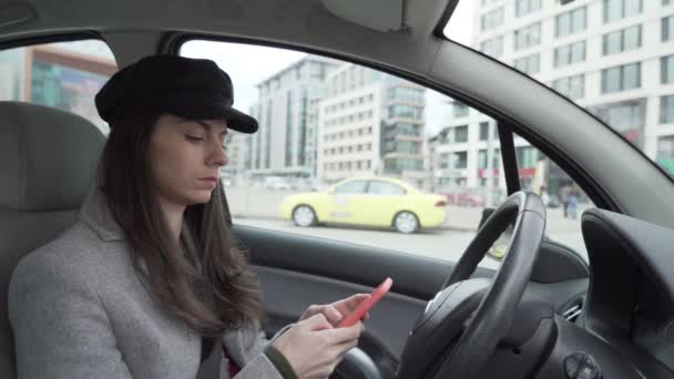 Senhora de negócios usando smartphone, digitando na tela enquanto espera alguém em seu carro — Vídeo de Stock