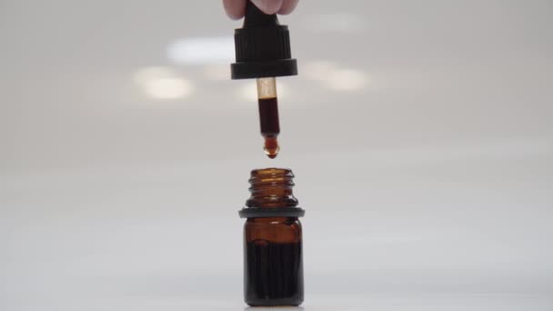 CBD μπουκάλι σταγονόμετρο λαδιού κάνναβης απομονωμένο σε λευκό φόντο — Αρχείο Βίντεο