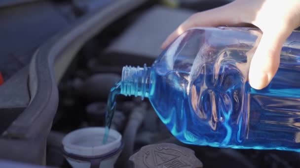 Vrouw hand langzaam vullen auto reservoir met ruitenwisser vloeistof — Stockvideo