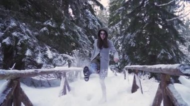 Soğuk bir kış gününde kar tekmelerken eğlenen bir kız.