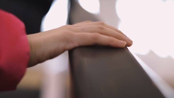 Vista cercana de la mano de la mujer sosteniendo pasamanos en escaleras mecánicas — Vídeos de Stock