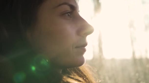 Мрійлива дівчина їде сама під час заходу сонця — стокове відео