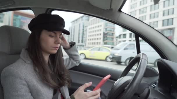 Mladá žena s černým kloboukem sedí v autě čeká — Stock video