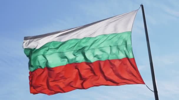 Bandera de Bulgaria ondeando con fuerte viento contra el cielo azul nublado — Vídeo de stock