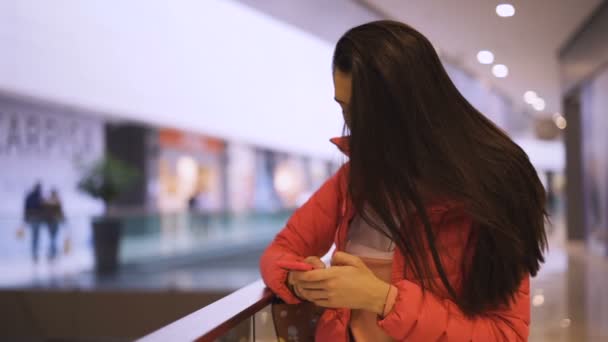 Attraktive Frau checkt Nachrichten am Telefon und fixiert ihre Haare — Stockvideo