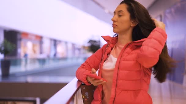 Элегантная девушка чинит волосы, наблюдая за экраном смартфона — стоковое видео