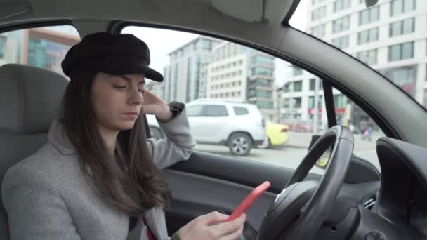 Fille en utilisant smartphone dans la voiture en attendant quelqu'un — Video