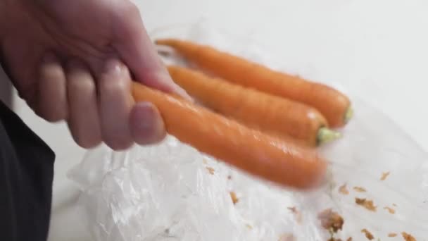 Ženské ruce loupající mrkvovou kůži nožem — Stock video