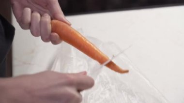 Kadın eli bıçakla havuç soyarken