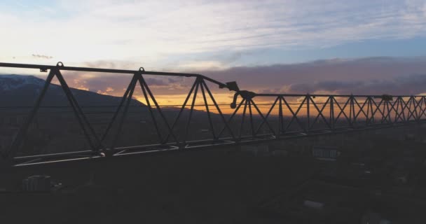 Silhouette eines Baukrans auf Susnet mit bunten Wolken — Stockvideo