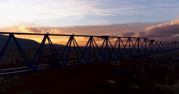 Hoher Turmdrehkran Silhouette auf Baustelle bei Sonnenuntergang — Stockvideo
