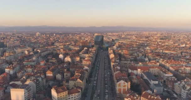 Boulevard con el tráfico de la ciudad en el paisaje del atardecer con coloridos tejados — Vídeos de Stock