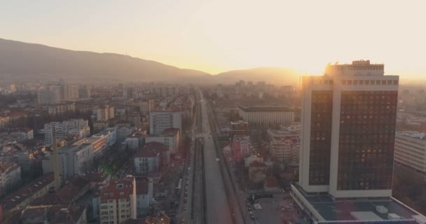 Magas irodaház naplementekor békés városi körúttal Szófiában, Bulgáriában — Stock videók